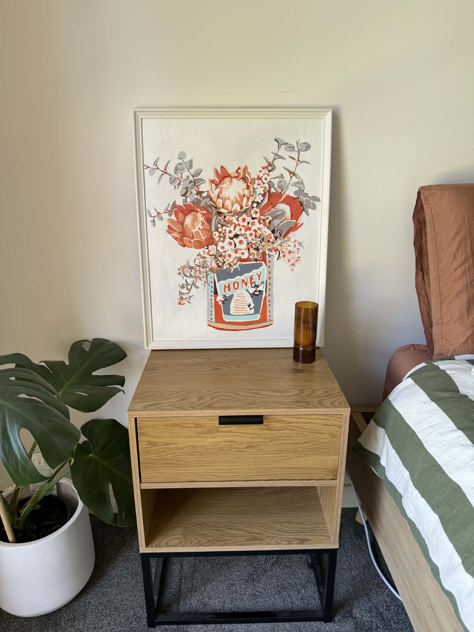 Framed painting of native flowers in a vintage honey tin